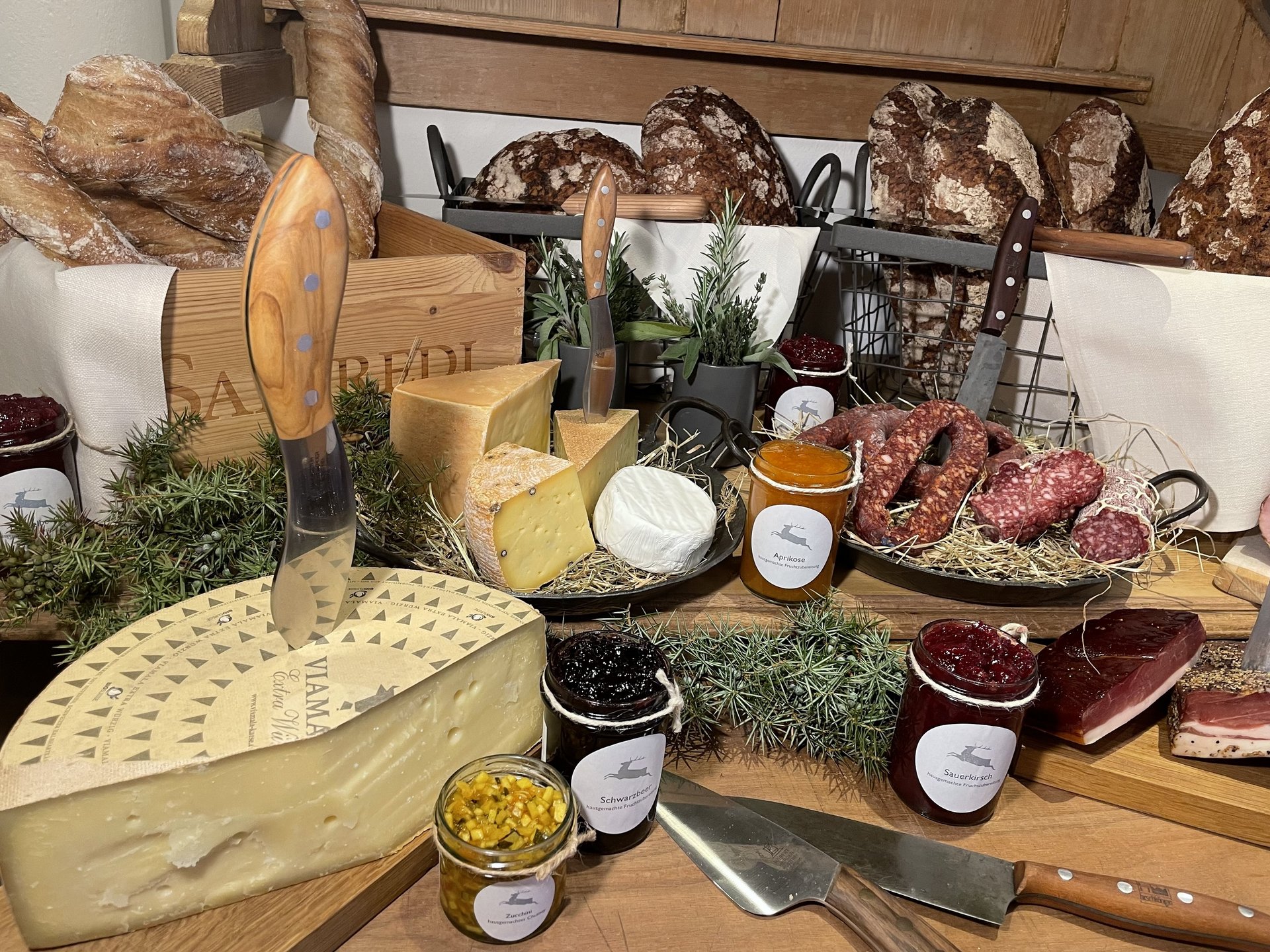 Inn & Restaurant in Parsberg serving regional cuisine Selection of cheese, bread, sausages and jams on wooden table with knives