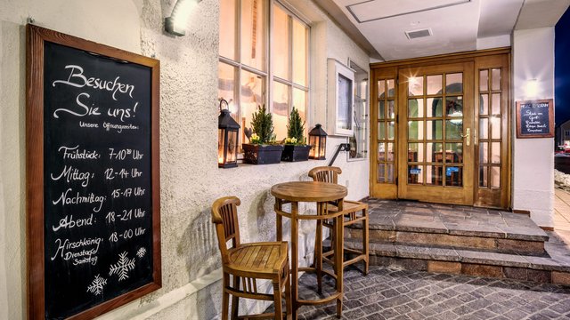 Romantik Hotel in Upper Palatinate: Come back soon! Outdoor area of a restaurant with chalkboard and wooden chairs by the entrance