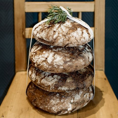 Guesthouse in Parsberg: A salute to great taste Four round loaves of bread stacked on a wooden chair dusted with flour