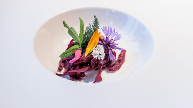 Romantik Hotel Hirschen: Frühstück Fein angerichtete rote Gemüsestreifen mit essbaren Blüten und Kräutern auf weißem Teller