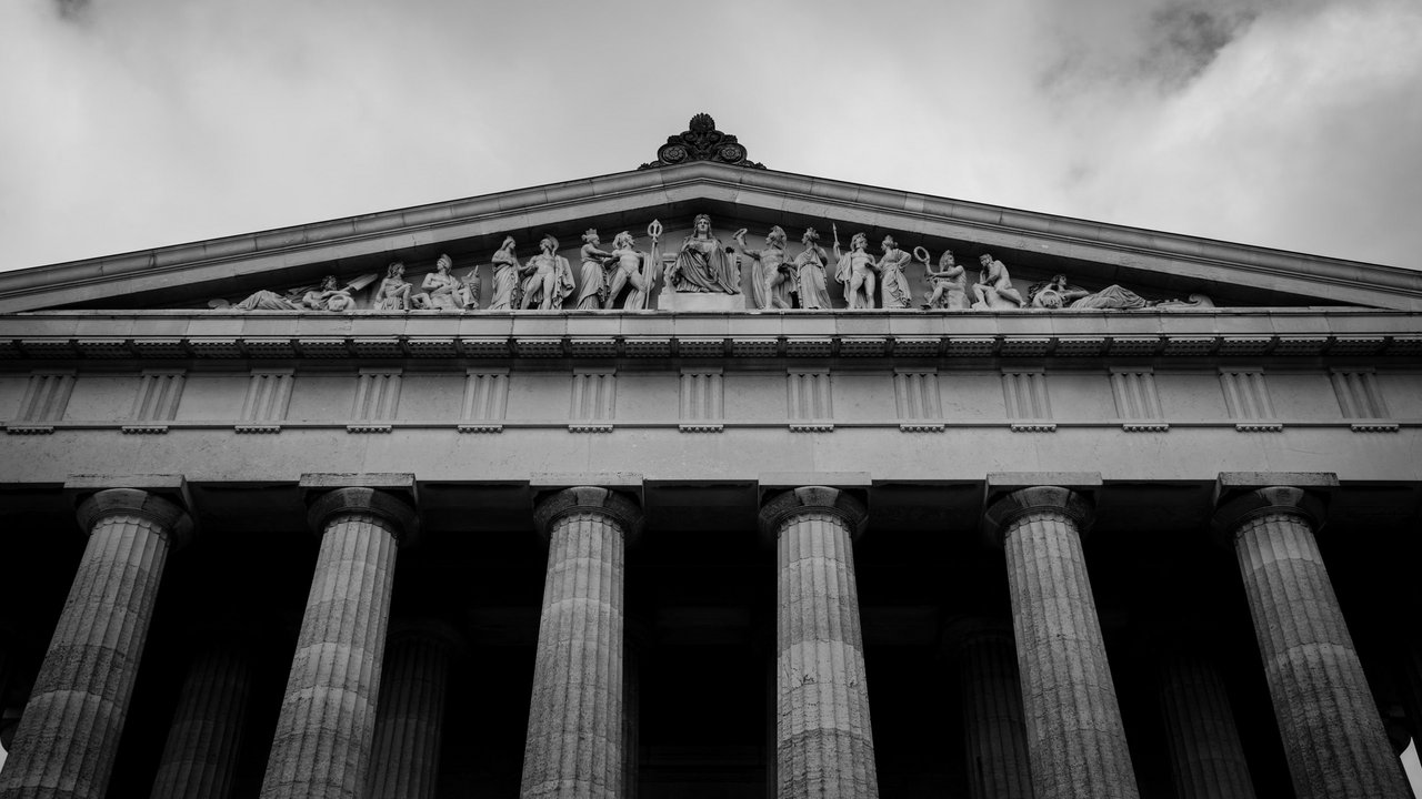 Antikes Gebäude mit Säulen und Figuren in einem Dreiecksgiebel