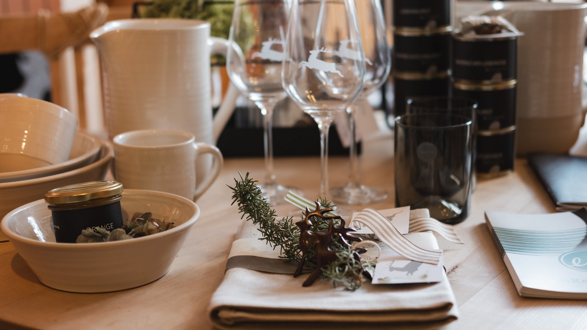Eco-friendly hotel in Germany with Hirschenmanufaktur Table with glasses, ceramic dishes, and decorated cutlery set
