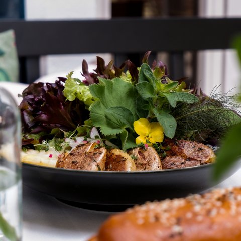 Kulinarik & Genuss in der Oberpfalz Frischer Salat und gebratene Kartoffeln auf einem schwarzen Teller