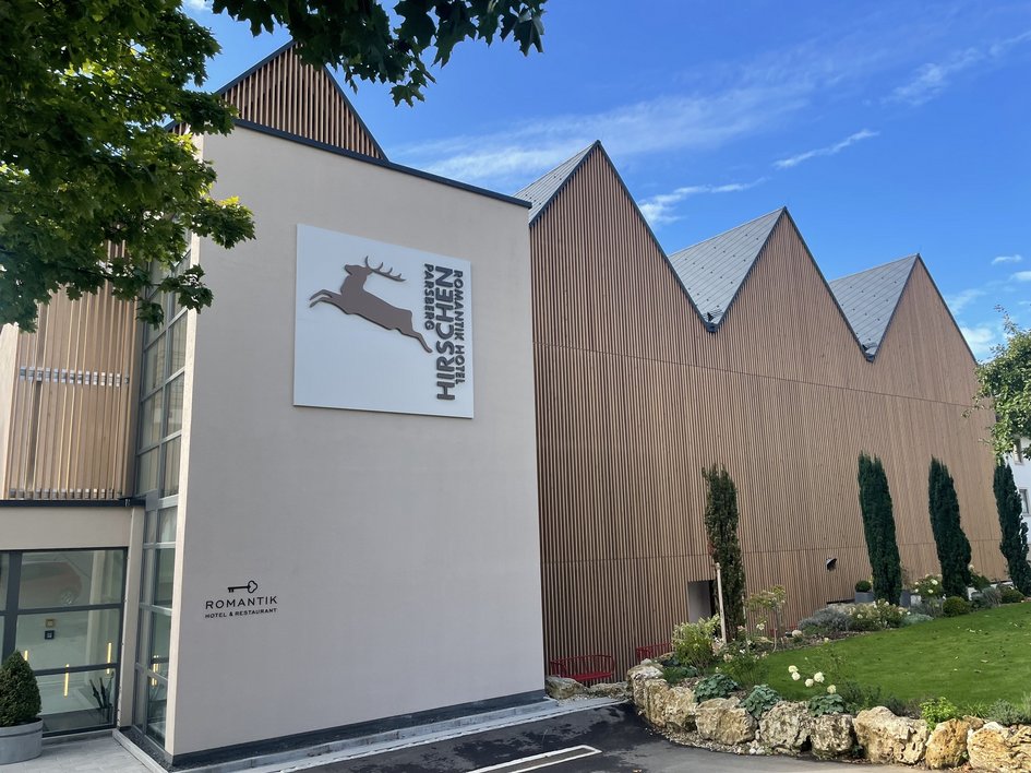Looking for somewhere for conferences in Bavaria? View of Romantik Hotel Hirschen with modern wooden facade on a sunny day