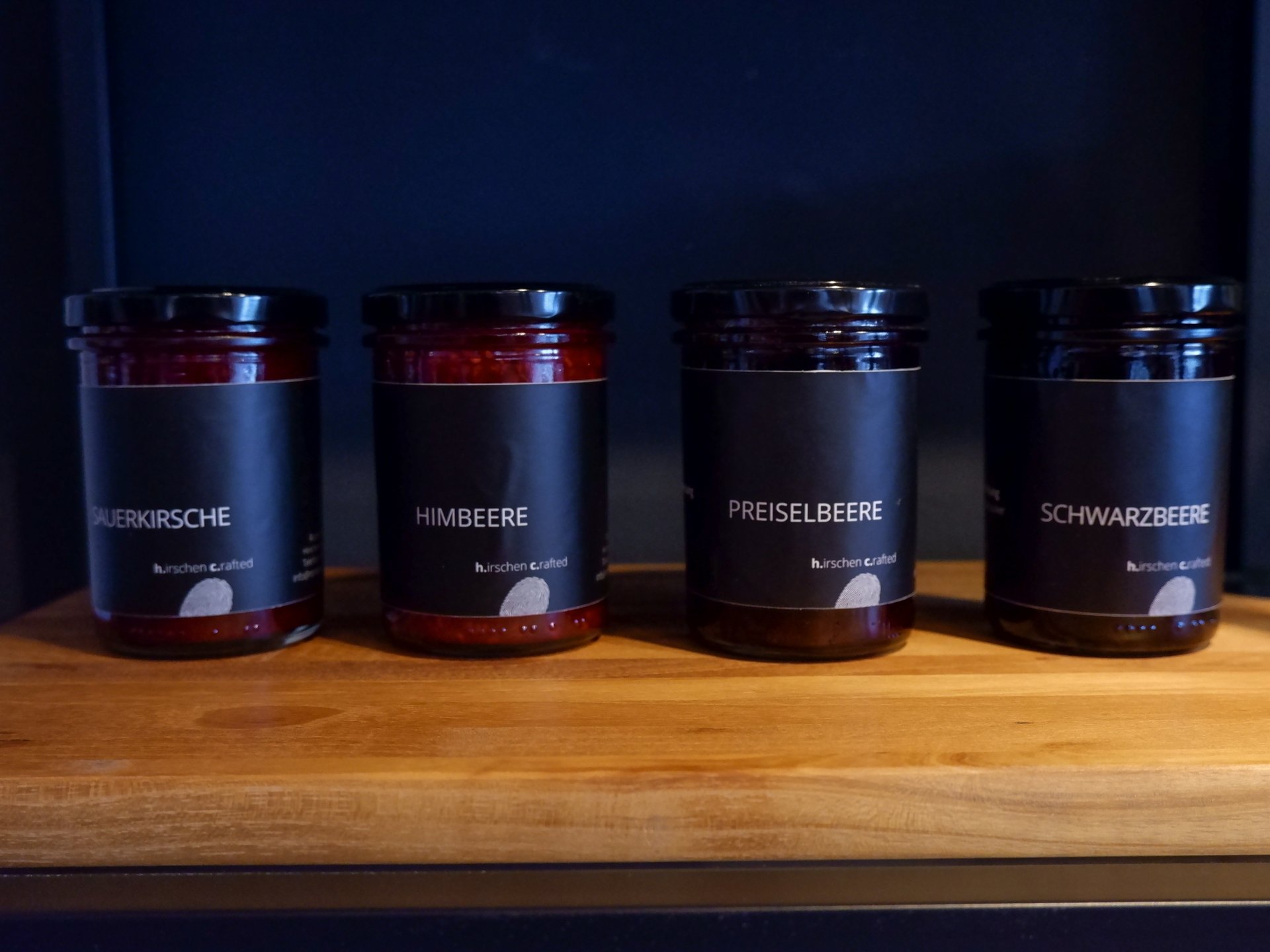 Nachhaltiges Hotel in Bayern mit eigener Manufaktur Four jars of different fruit jams on a wooden board