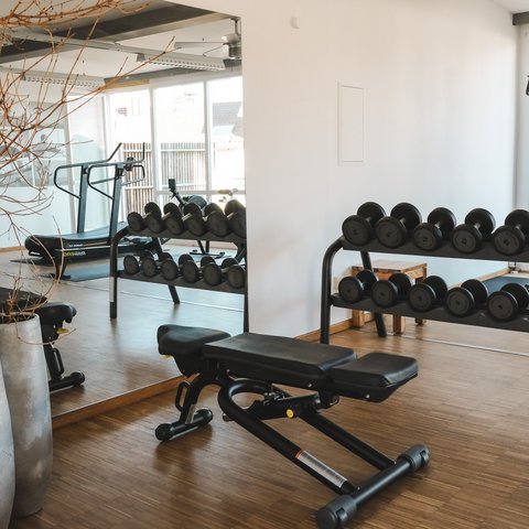 Fitnessraum Small gym with dumbbells, workout bench, and treadmill