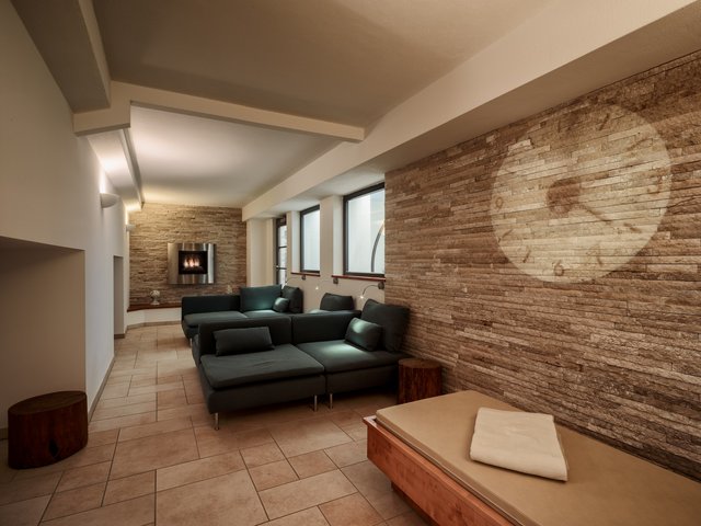 Romantik Hotel Hirschen: Bildergalerie Gemütlicher Wohnbereich mit Kamin und projizierter Uhr an Wand