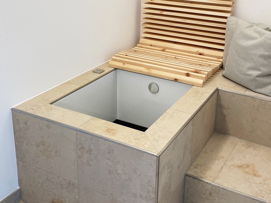 Wellnesshotel in der Oberpfalz: schwitzen & schwimmen Moderner Sitzbereich mit steinverkleidetem Fußbad und Holzlehne