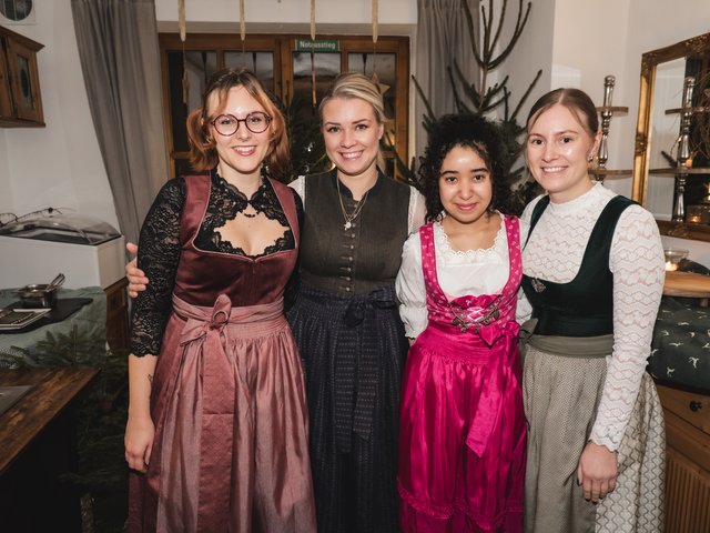 Romantik Hotel Hirschen: Bildergalerie Vier Frauen in traditionellen Dirndlkleidern lächeln in einer gemütlichen Küche