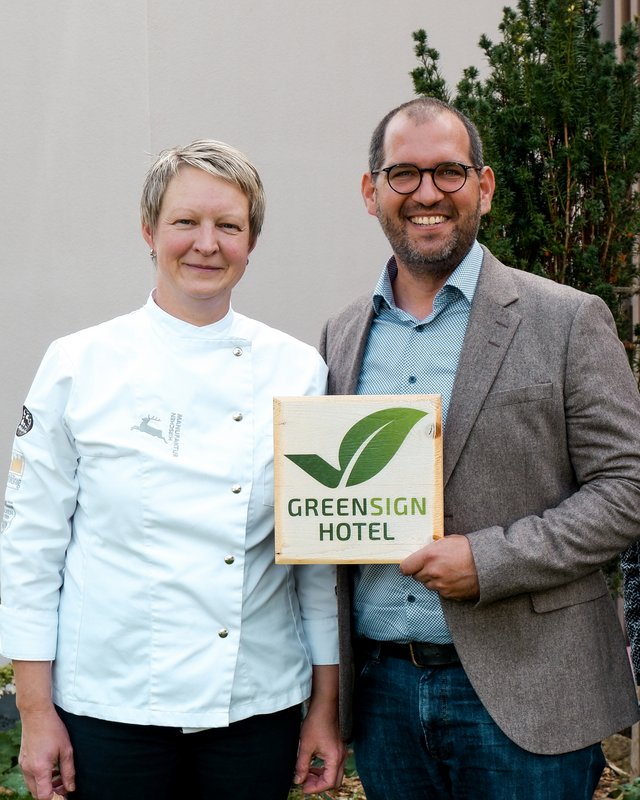 Brunch - das Langschläferfrühstück Zwei Personen, eine in Kochjacke, halten Greensign Hotel Schild