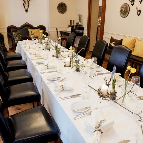 Gasthof Parsberg: Ein Gruß an den guten Geschmack Eleganter, gedeckter Esstisch mit schwarzen Stühlen und Frühlingsdekoration