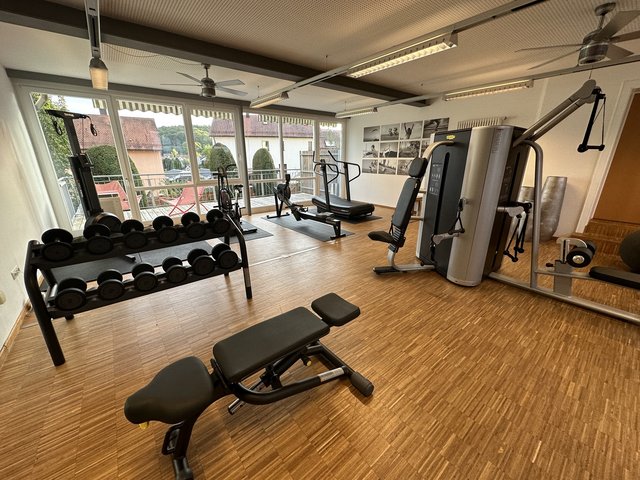Romantik Hotel Hirschen: picture gallery Bright gym room with workout machines and dumbbells by large windows