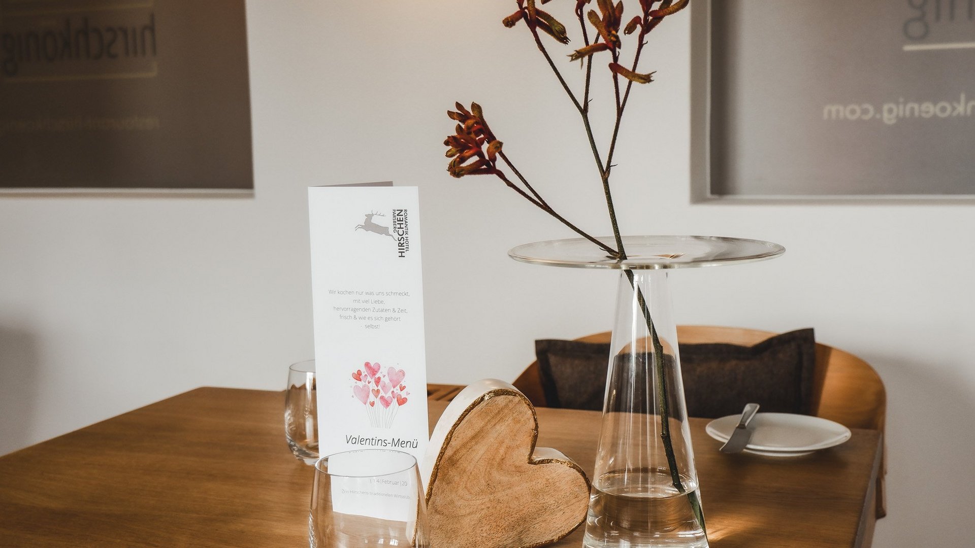 Valentine's Day 2026 Table with Valentine's menu, wooden heart, and vase with branches in cozy room