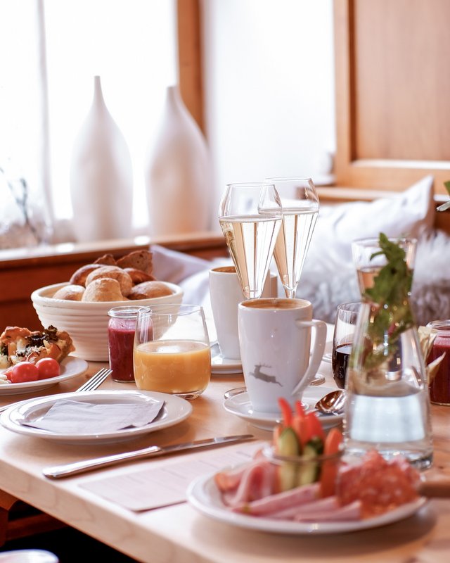 Hochzeitslocation Oberpfalz gesucht? Frühstückstisch mit Kaffee, Orangensaft, Gebäck, Wurst und Blumen in gemütlicher Holzumgebung