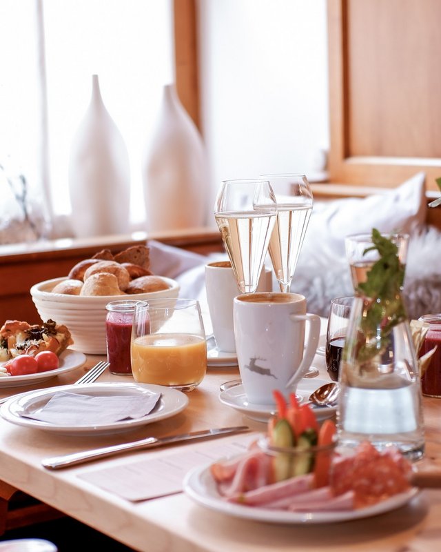 Hochzeitslocation Oberpfalz gesucht? Frühstückstisch mit Kaffee, Orangensaft, Gebäck, Wurst und Blumen in gemütlicher Holzumgebung