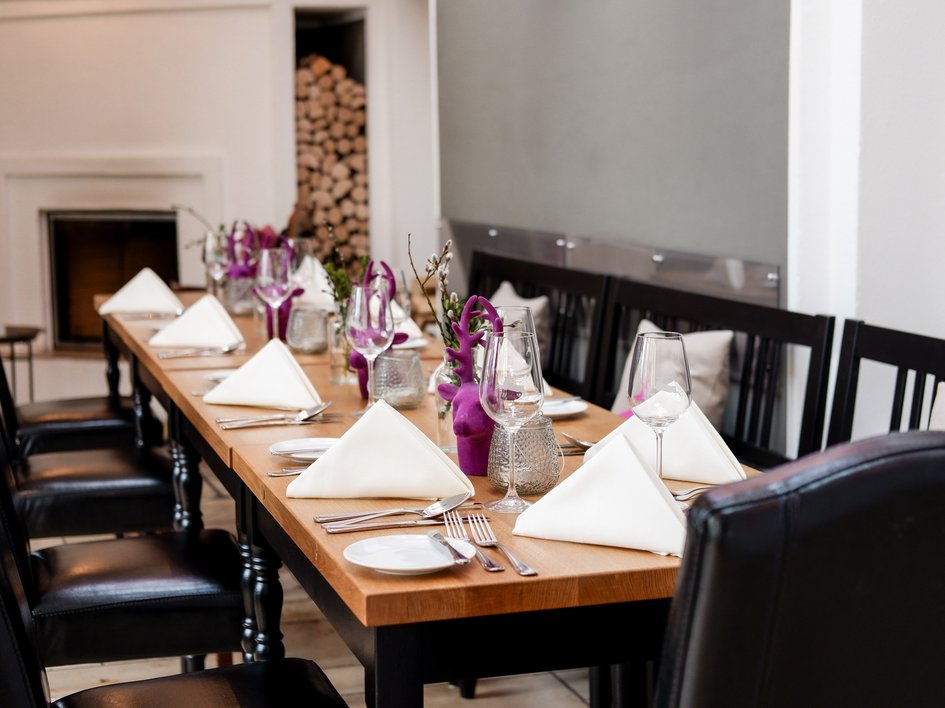 Leistungen und Preise für Tagungen und Konferenzen Eleganter Esstisch mit weißen Servietten und lila Dekoration in modernem Raum