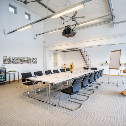 Looking for somewhere for conferences in Bavaria? Bright modern conference room with table, chairs, and presentation area