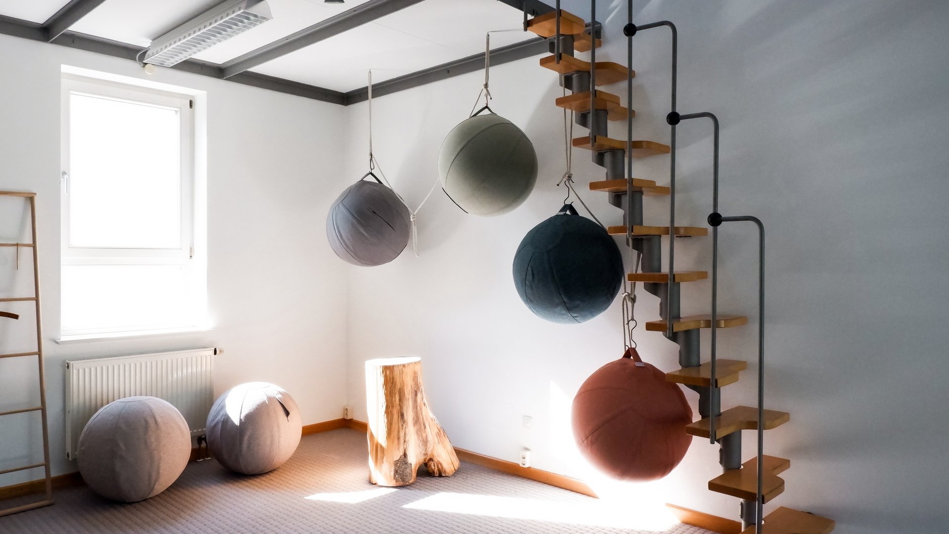 Tagung mit Mehrwert Zimmer mit hängenden und stehenden Sitzbällen und Holzstufen