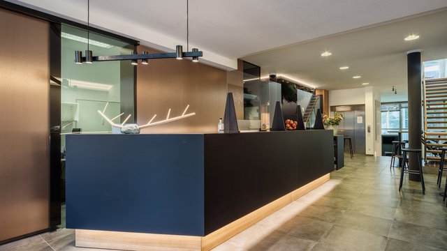 Revel in anticipation Modern reception area with black counter and decorative lighting