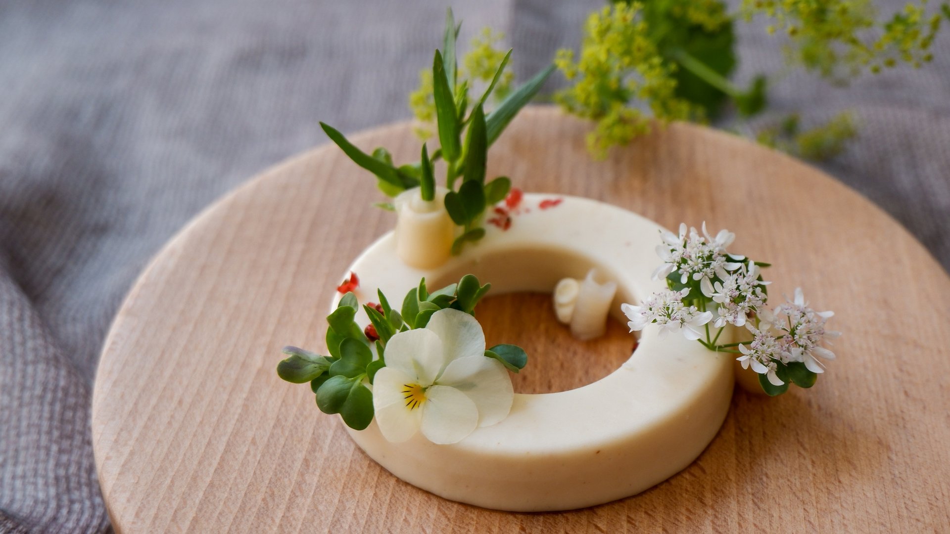Romantik Hotel Hirschen: cuisine Round cheese ring decorated with edible flowers and herbs on wooden board