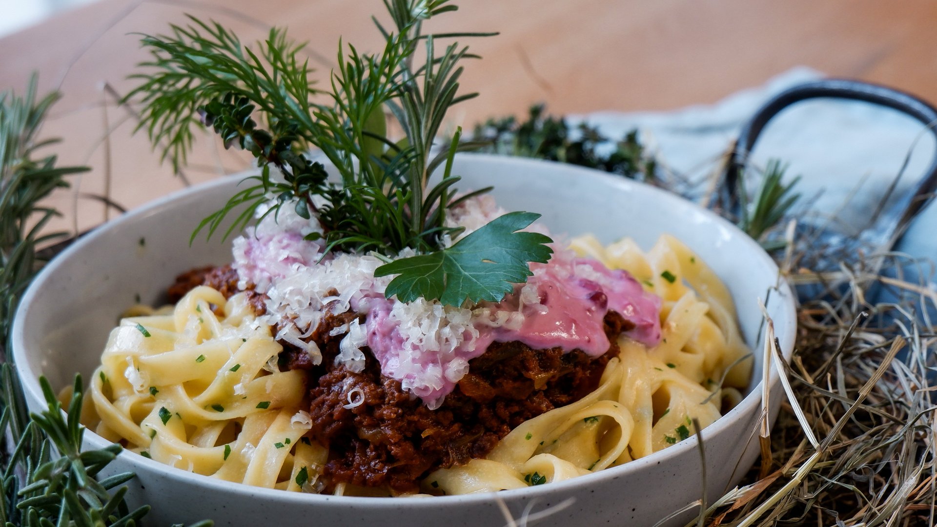 Guesthouse in Parsberg: A salute to great taste Pasta with Bolognese, cheese, and herbs served in a bowl on a table