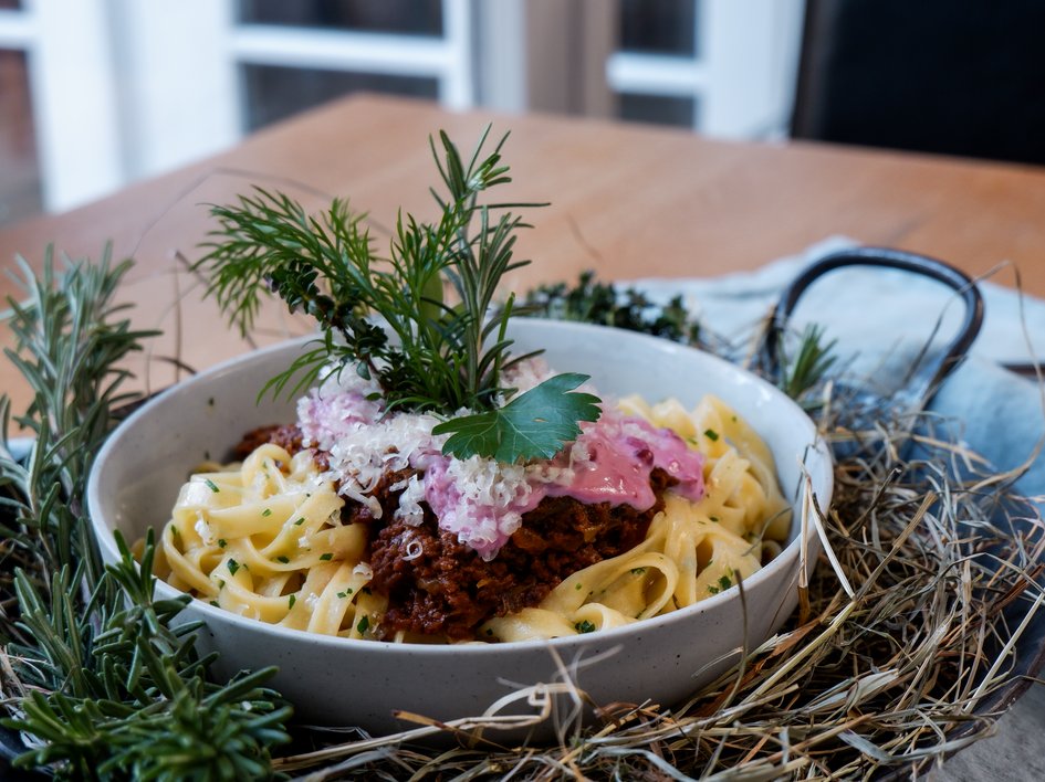 Gasthof Parsberg: Ein Gruß an den guten Geschmack Nudeln mit Bolognese, Käse und Kräutern serviert in einer Schale auf einem Tisch