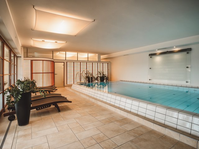 Romantik Hotel Hirschen: Bildergalerie Hallenbad mit Liegestühlen und Pflanzen in modernem Wellnessbereich