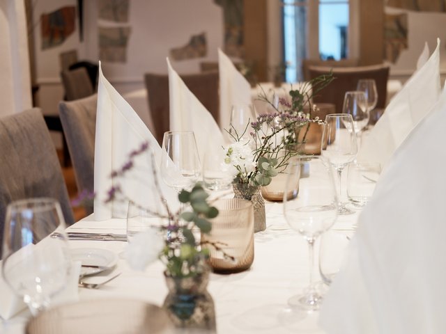 Romantik Hotel Hirschen: Kulinarik Eleganter gedeckter Tisch mit weißen Servietten und Blumen in Vasen
