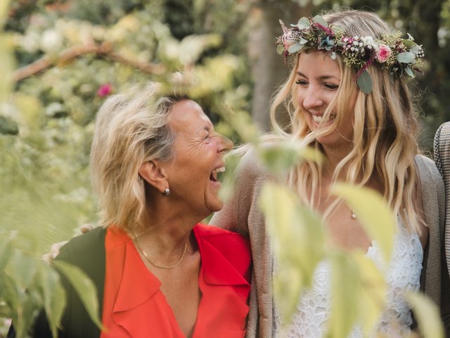 Romantik Hotel Hirschen: Bildergalerie Zwei Frauen lachen zusammen in einem Garten, eine mit Blumenkranz im Haar