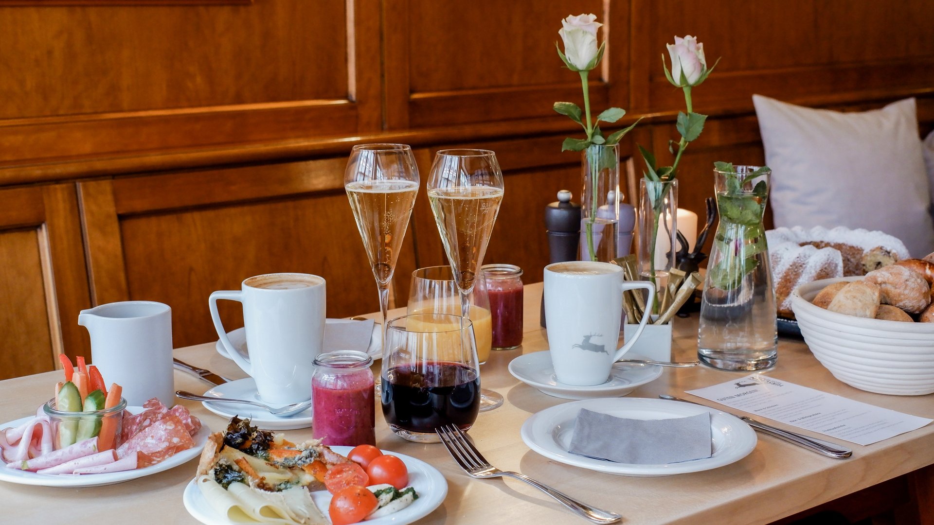 Romantik Hotel Hirschen: Frühstück Frühstückstisch mit Kaffee, Sekt, Säften, Gebäck und frischen Rosen
