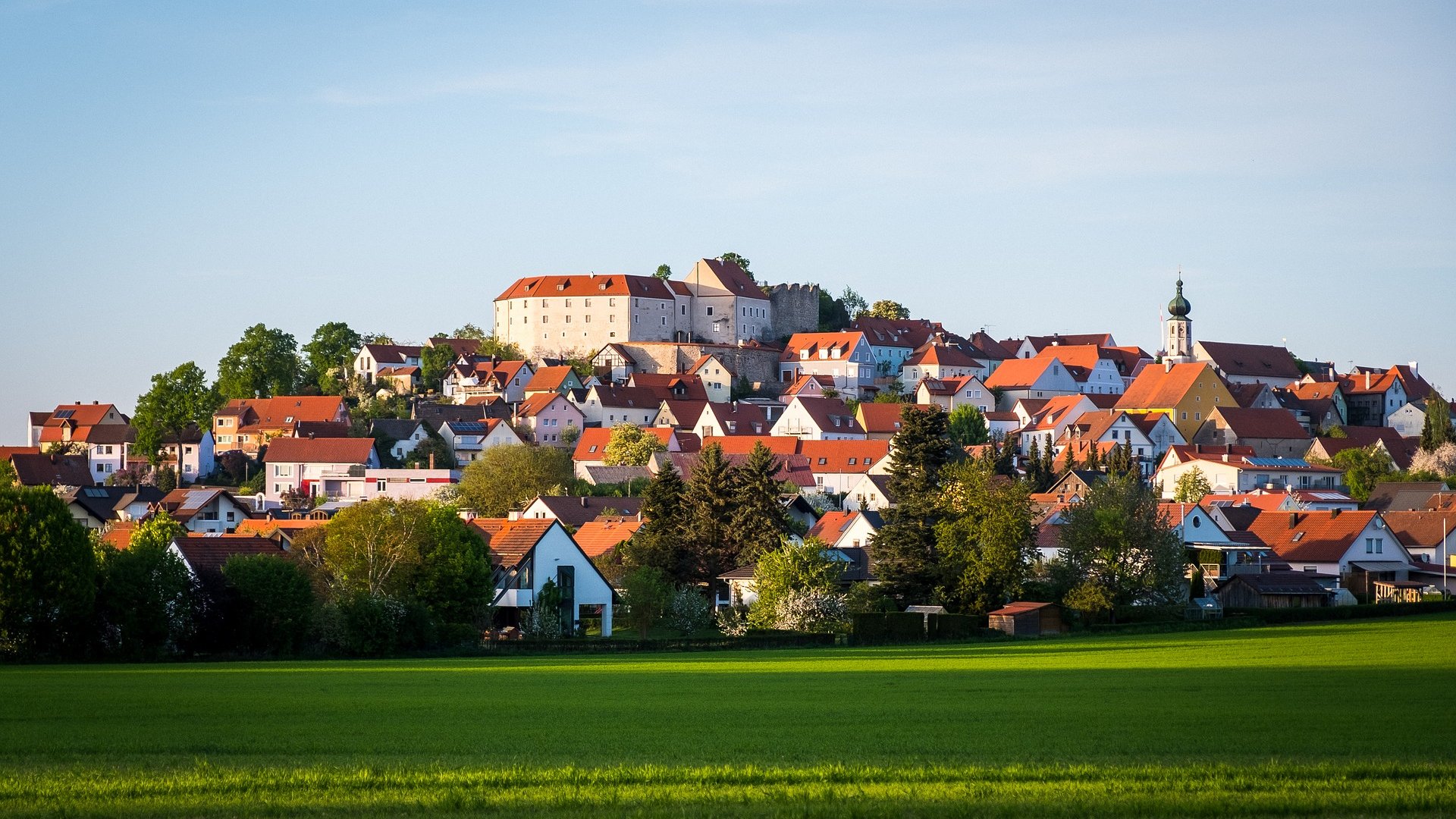 Familienhotel Oberpfalz: Hier gibt’s so viel zu erleben! Blick auf ein Dorf mit Schloss und roten Dächern bei Sonnenschein