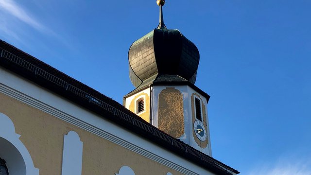 Romantik Hotel Hirschen: Blog Kirchturm mit Zwiebelkuppel und Uhr bei klarem Himmel