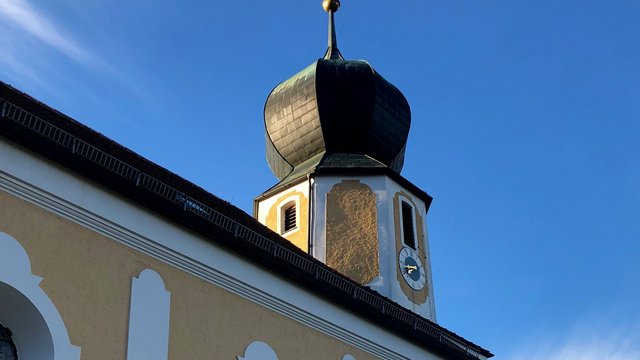 Romantik Hotel Hirschen: Blog Kirchturm mit Zwiebelkuppel und Uhr bei klarem Himmel