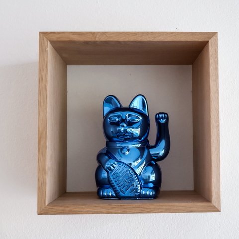 Looking for somewhere for conferences in Bavaria? Blue metallic lucky cat figurine in a wooden wall shelf