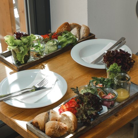 Tageswellness in der Oberpfalz Tisch mit zwei gedeckten Plätzen und Brot, Salat und Saucen in Gläsern
