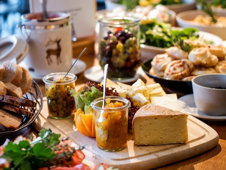 Gasthof Parsberg: Ein Gruß an den guten Geschmack Buffet mit Käse, Marmelade, Brot und Vorspeisen auf einem Holztisch