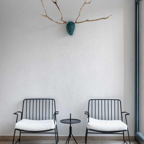 Tageswellness in der Oberpfalz Minimalistischer Innenraum mit zwei Stühlen, kleinem Tisch und Wanddekoration