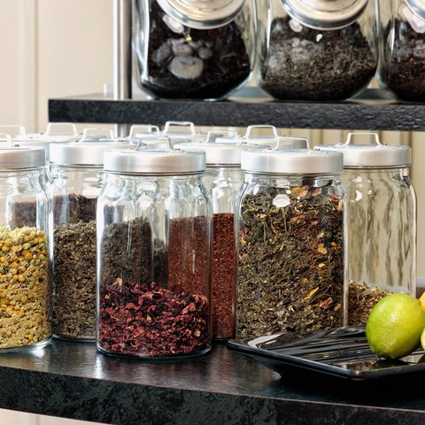 Looking for somewhere for conferences in Bavaria? Various loose teas in glass jars with citrus fruits on a tray