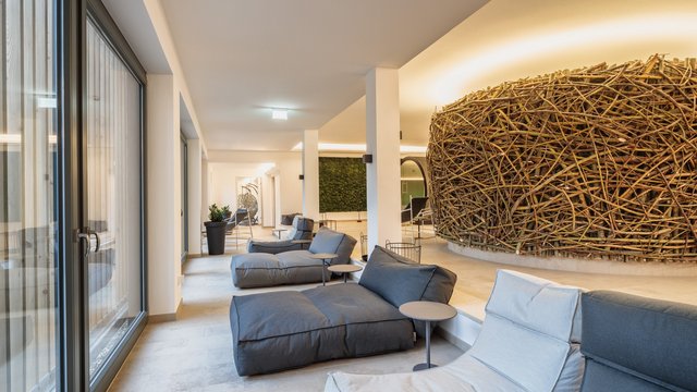 Romantik Hotel Hirschen: Blog Moderner Ruhebereich mit gemütlichen Sitzpolstern und großer Zweiginstallation