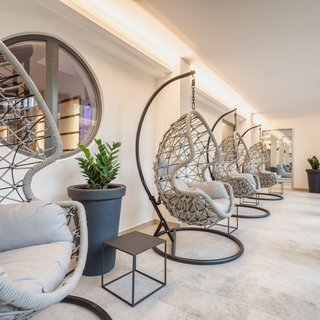 Brunch - das Langschläferfrühstück Moderne Hängesessel mit grauen Kissen in einem hellen Raum mit Pflanzen