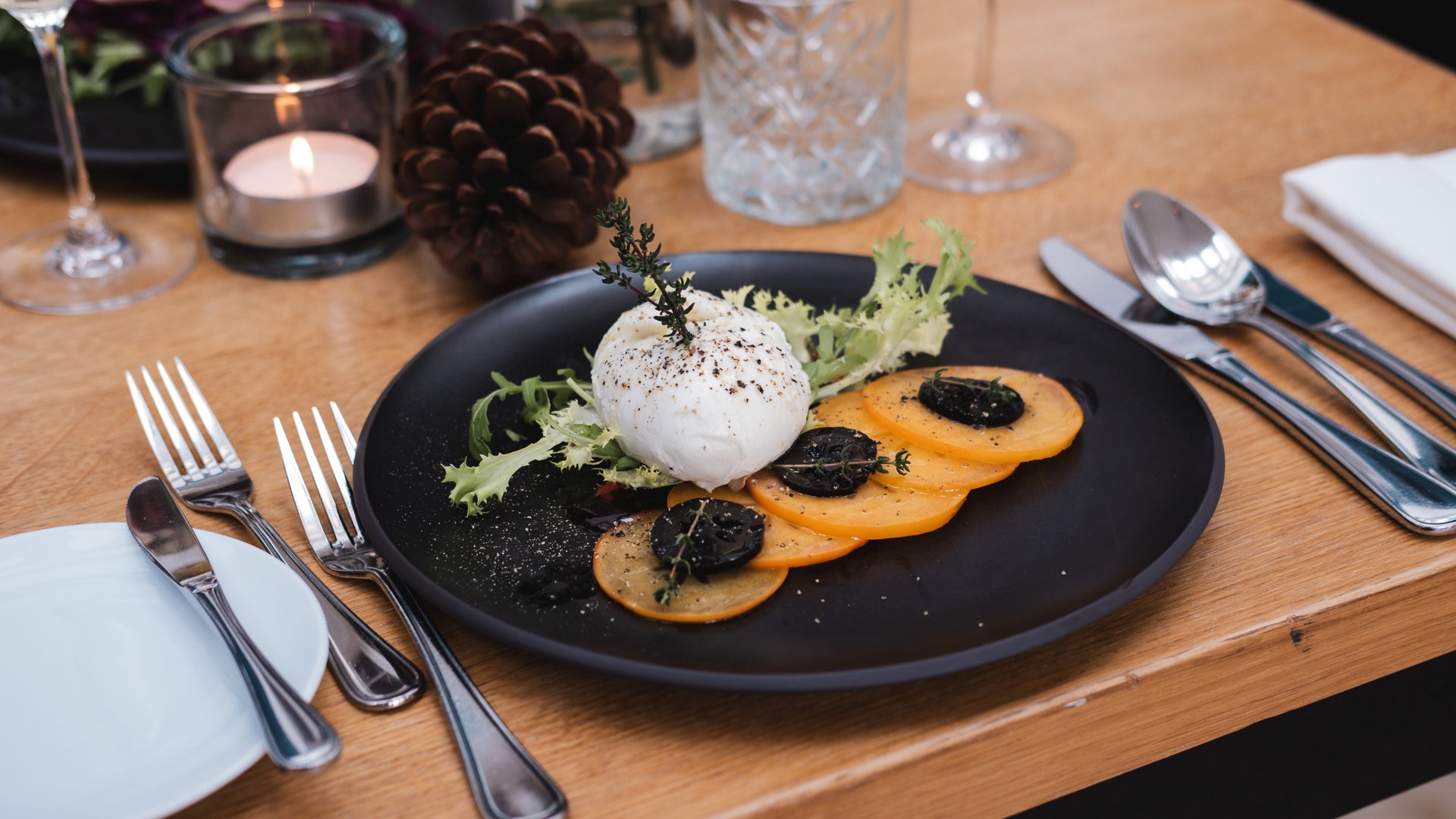 Romantik Hotel Hirschen: cuisine Elegant appetizer with white cheese balls and vegetables on a black plate