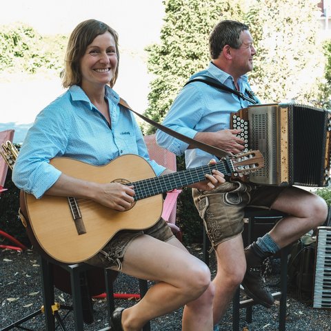 Kulinarik & Genuss in der Oberpfalz Zwei Musiker in Trachten spielen Gitarre und Akkordeon im Freien