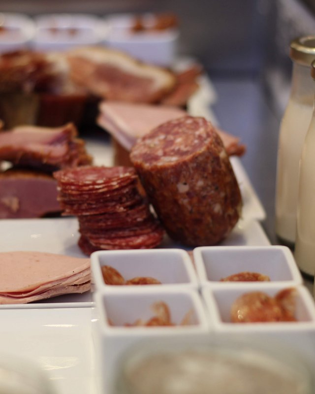 Looking for sustainable hotels in Germany? Various cold cuts and milk in small bottles on a buffet