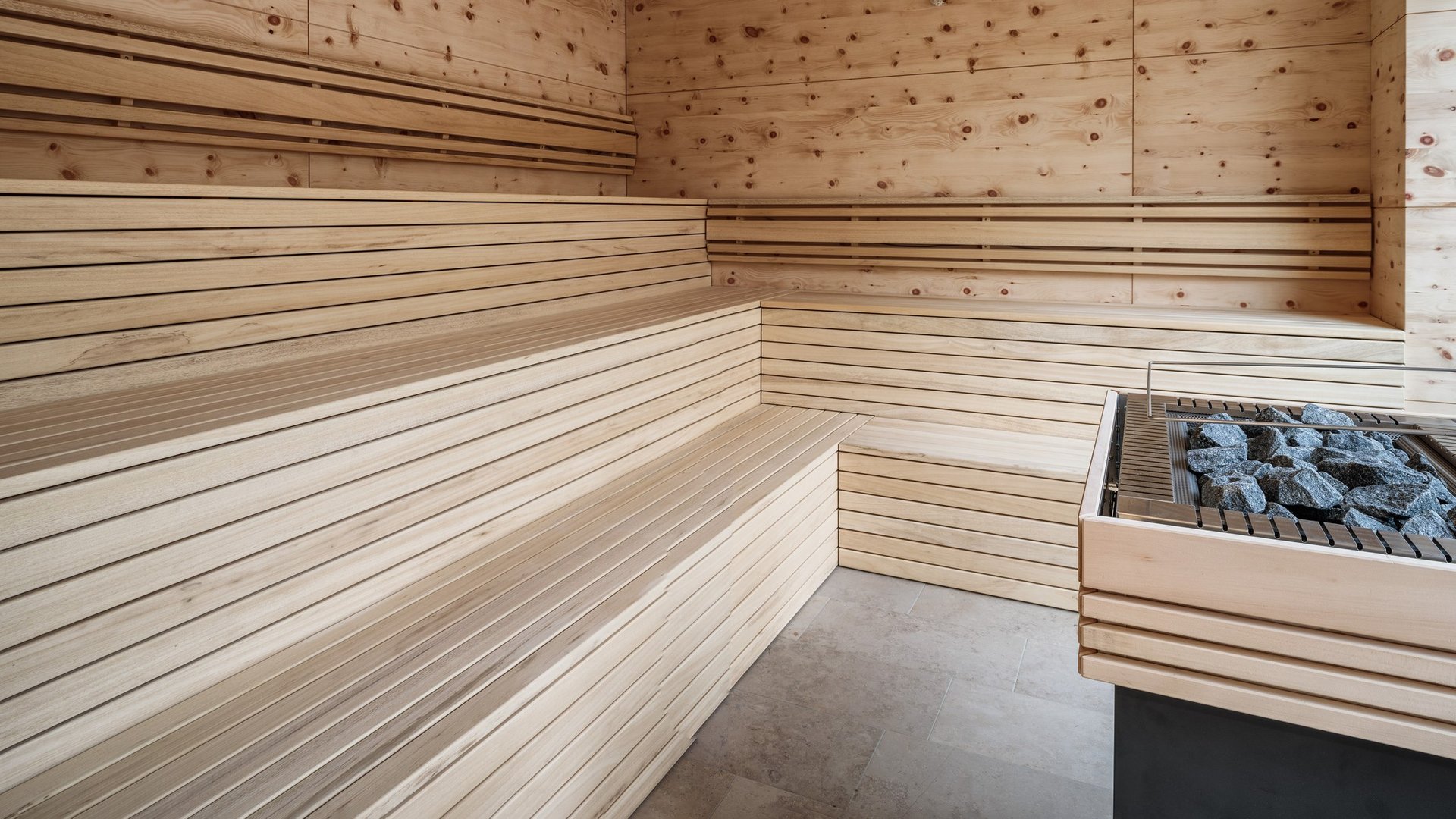 Wellness Modern sauna room with wooden paneling and stone heater