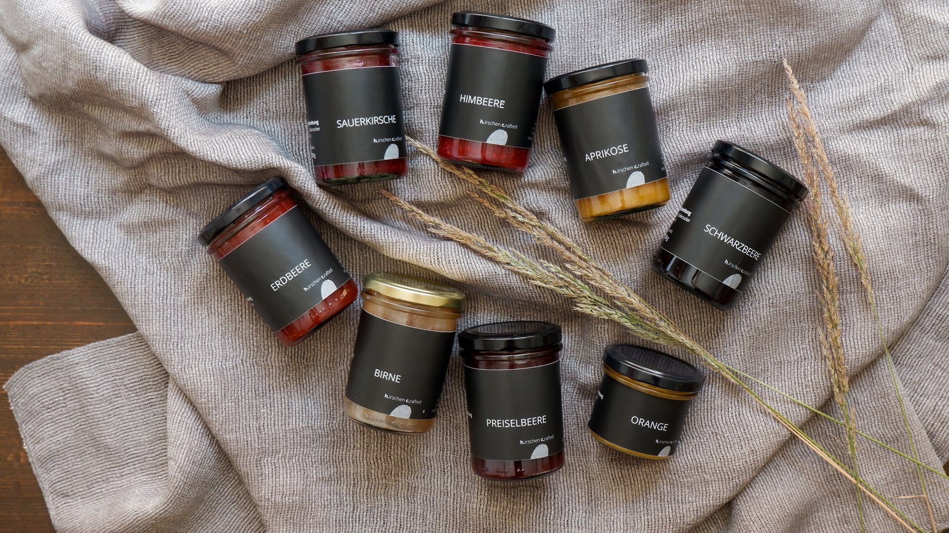 Eco-friendly hotel in Germany with Hirschenmanufaktur Various jam jars with black labels on gray blanket