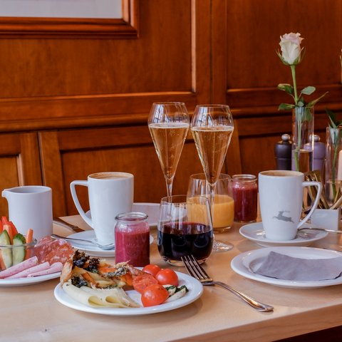 Romantik Hotel Hirschen: Frühstück Frühstückstisch mit Kaffee, Saft, Sekt, Wurst, Käse und Blumen