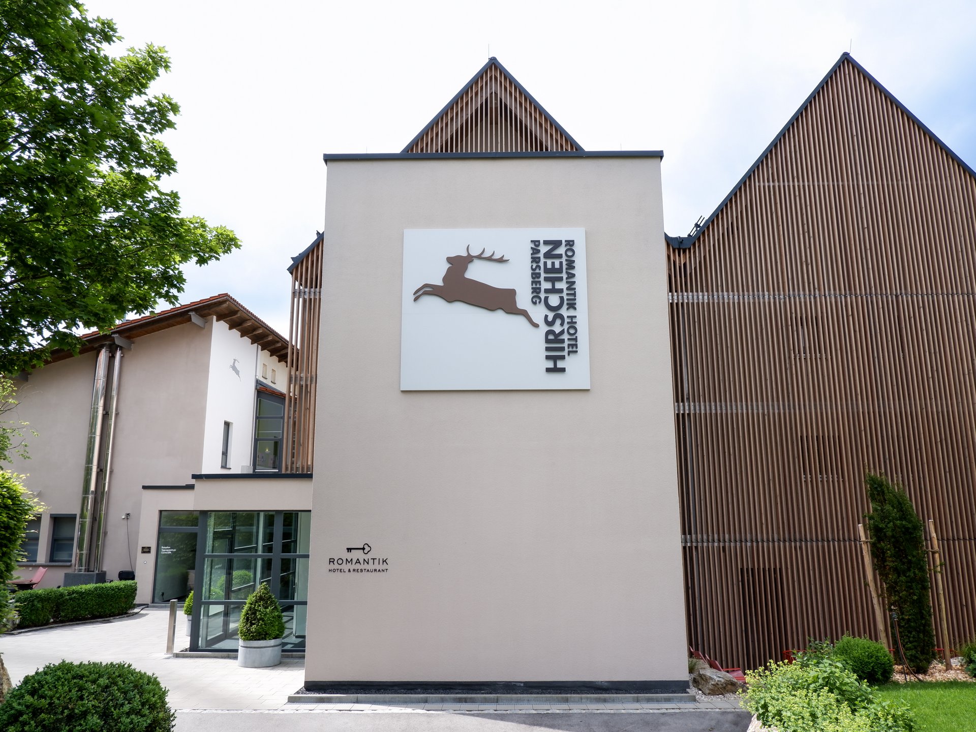 Wellnesshotel Parsberg – Romantik Hotel Hirschen Fassade des Romantik Hotel Hirschen in Parsberg mit Hirsch-Logo und moderner Holzverkleidung