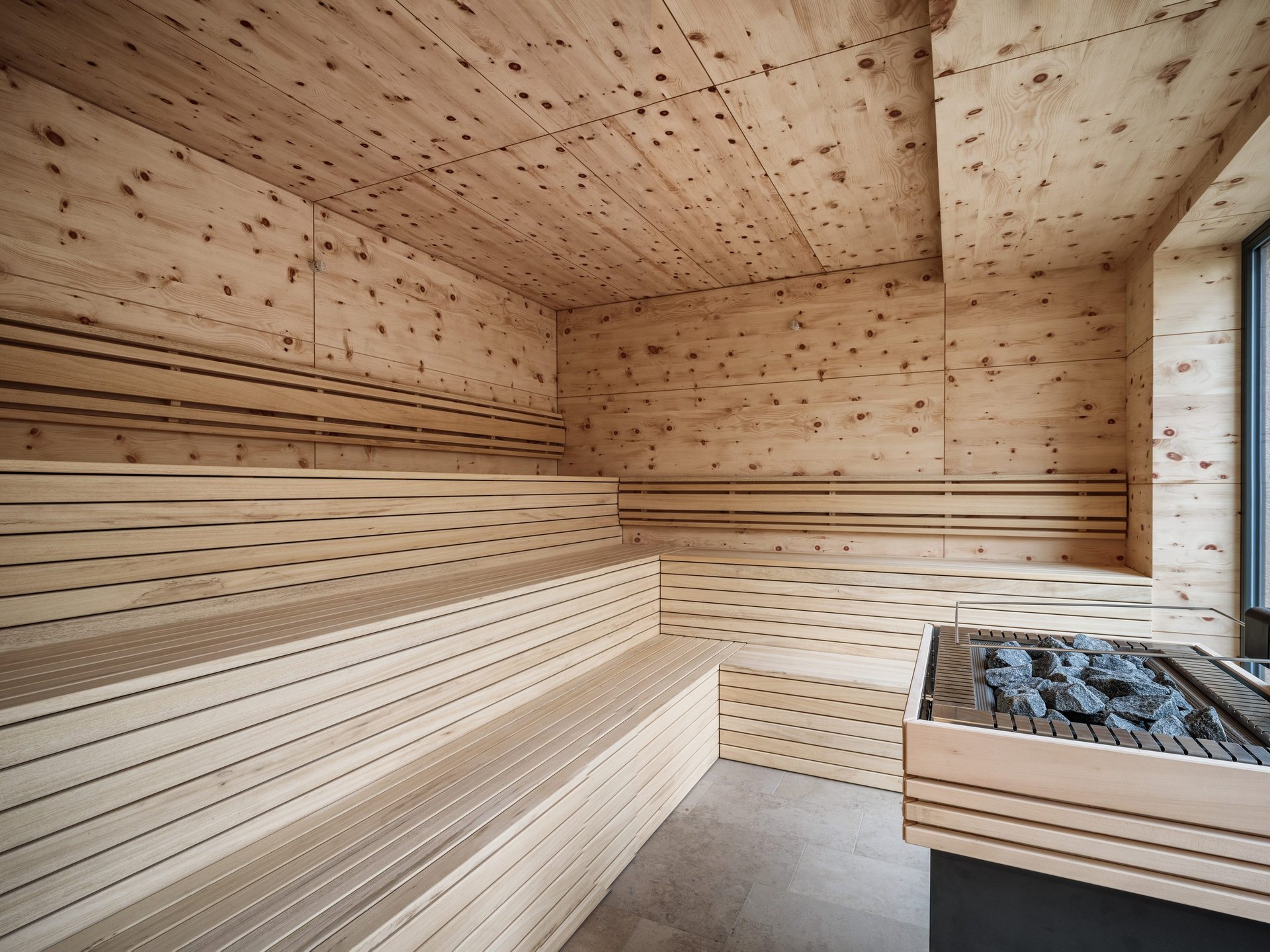 Saunas, Pool & Natural Pool in the Upper Palatinate | Romantik Hotel Hirschen Modern wooden sauna interior with stone heater and large seating benches