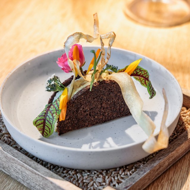 Restaurant in Parsberg: Enjoy gourmet Artistic gourmet dish with edible flowers and herbs on white plate
