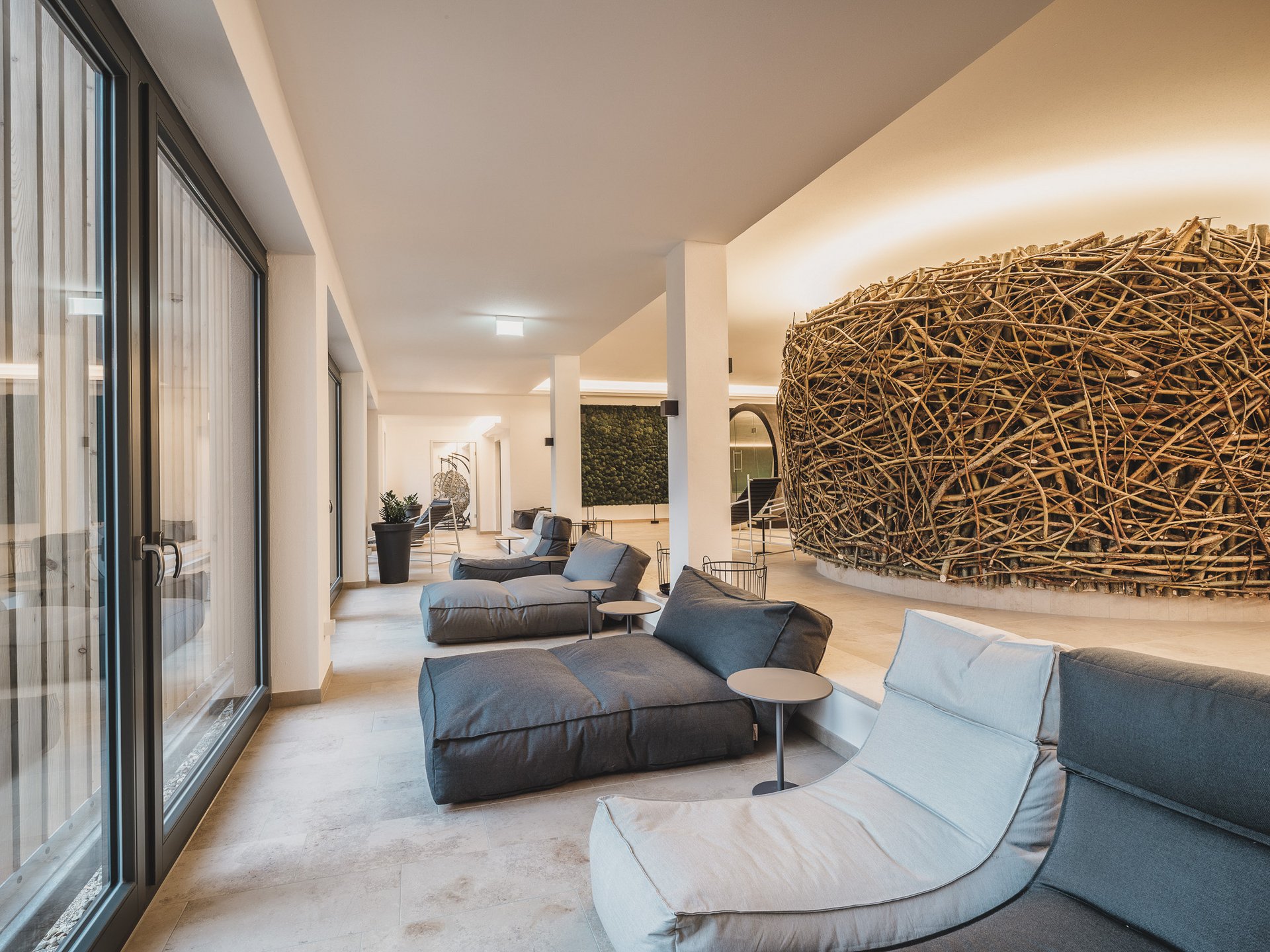 Wellness Moderner Lounge-Bereich mit gemütlichen Sesseln und großer Dekoration aus Ästen